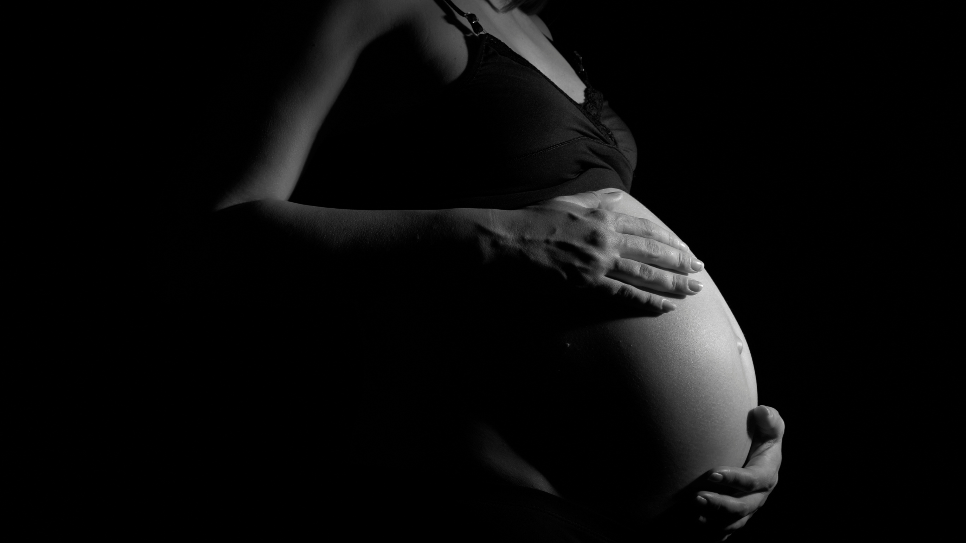 pregnant woman holding her tummy