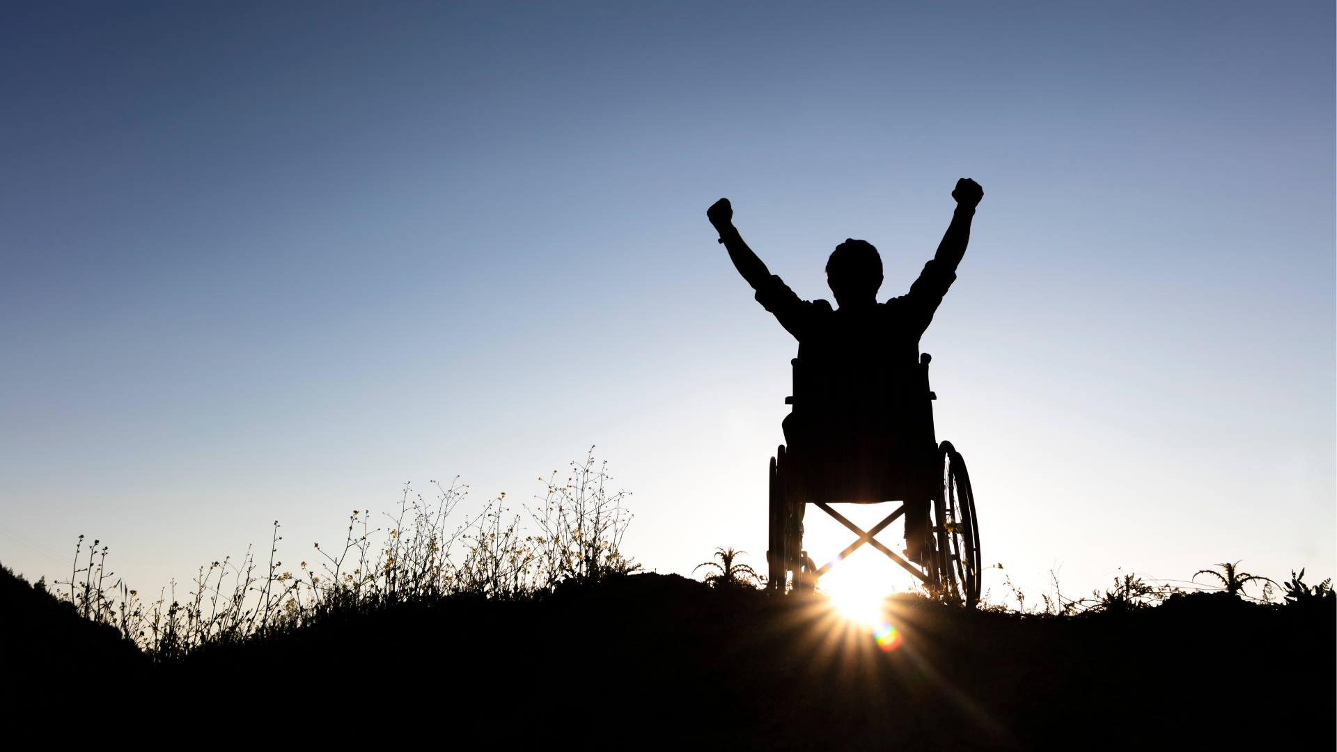 spina bifida person on a wheelchair fist bumping the sky