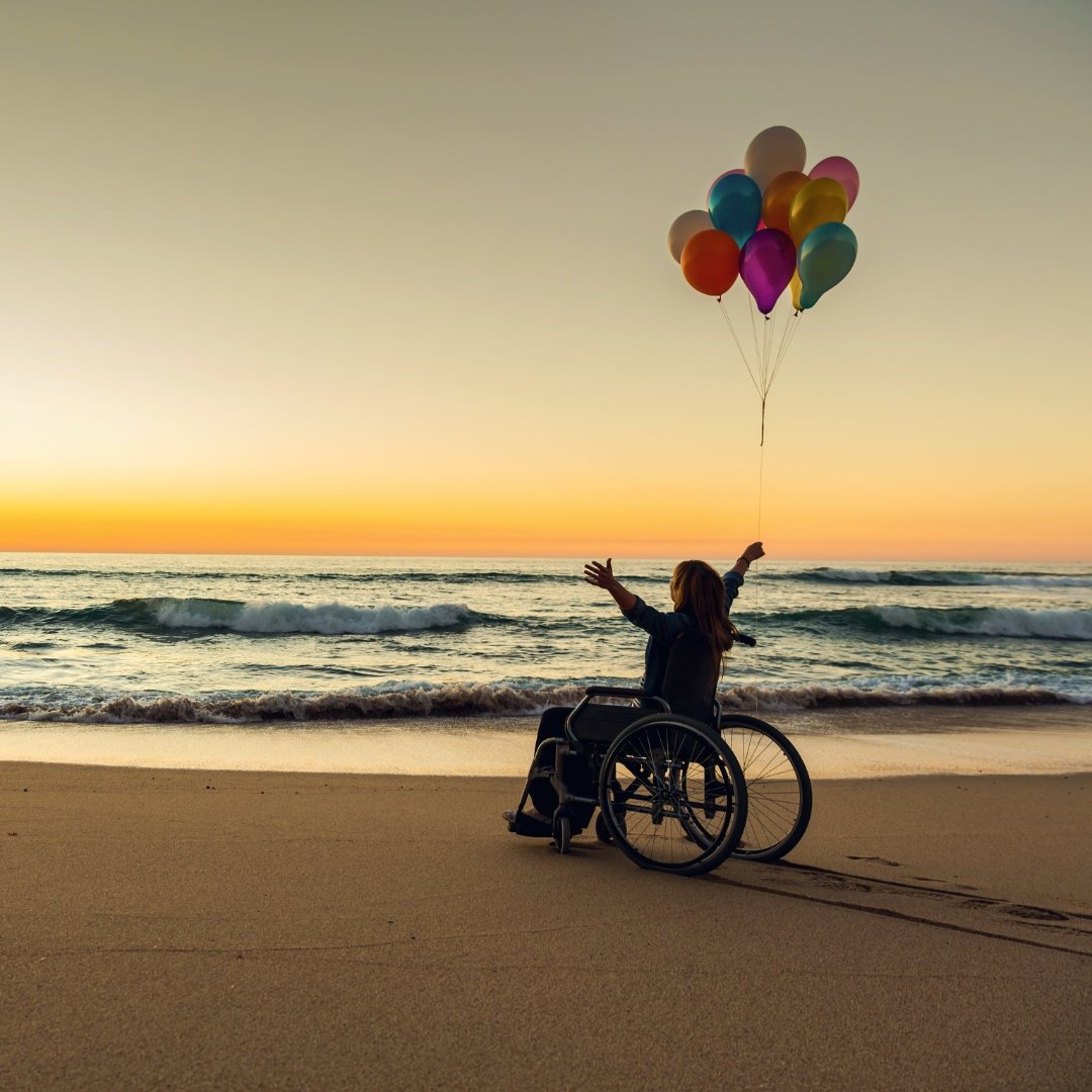 a woman on wheelchair enjoying freedom on the beach