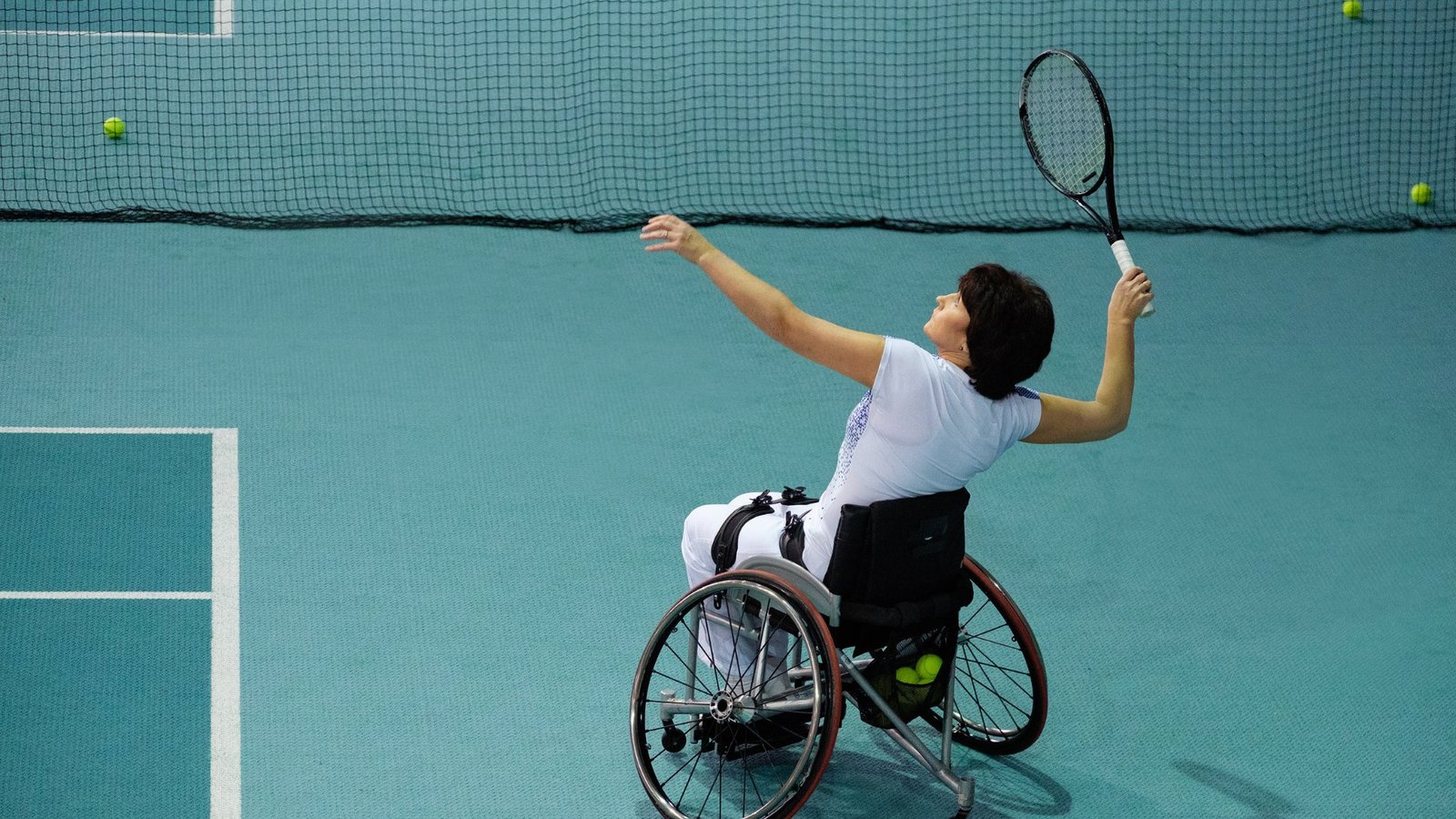 a woman with spina bifida playing tennis tournament on a wheelchair