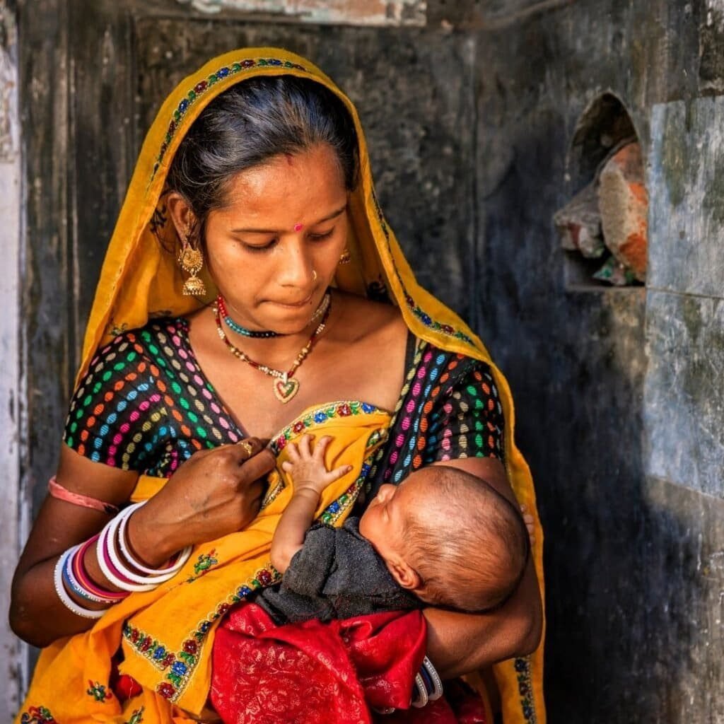 a new mother in a remote Indian town breast feeding her spina bifida baby